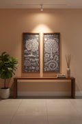 Two framed artworks on a wall above a wooden console table with decorative items.