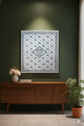 Decorative wall art with a geometric pattern on a dark green wall above a wooden cabinet.