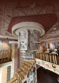 Decorative interior with intricate ceiling and wall designs, featuring a staircase.