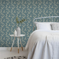 Bedroom with floral wallpaper, bed, side table, and decorative items.