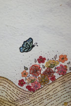 Embroidered design of a butterfly and flowers on fabric