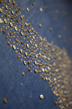 Close-up of gold sequins on a blue fabric background