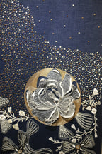 Decorative fabric with floral embroidery and sequins on a dark blue background