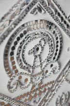Close-up of a metallic, intricate design on a white background