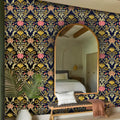 Decorative floral-patterned wall with a large mirror and bench in a bedroom setting.