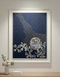 Framed artwork with floral design on a wall above a wooden surface.