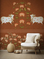 Decorative wall with cow and floral design, white armchair with beige cushions, and decorative vase.