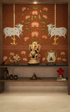 Decorative wall with cows on swings and floral patterns, featuring a statue of a deity on a shelf.