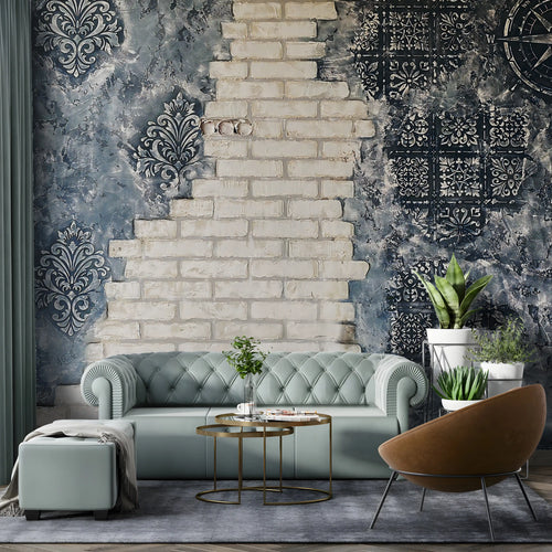 Modern living room with a gray sofa, decorative wall, and plants.
