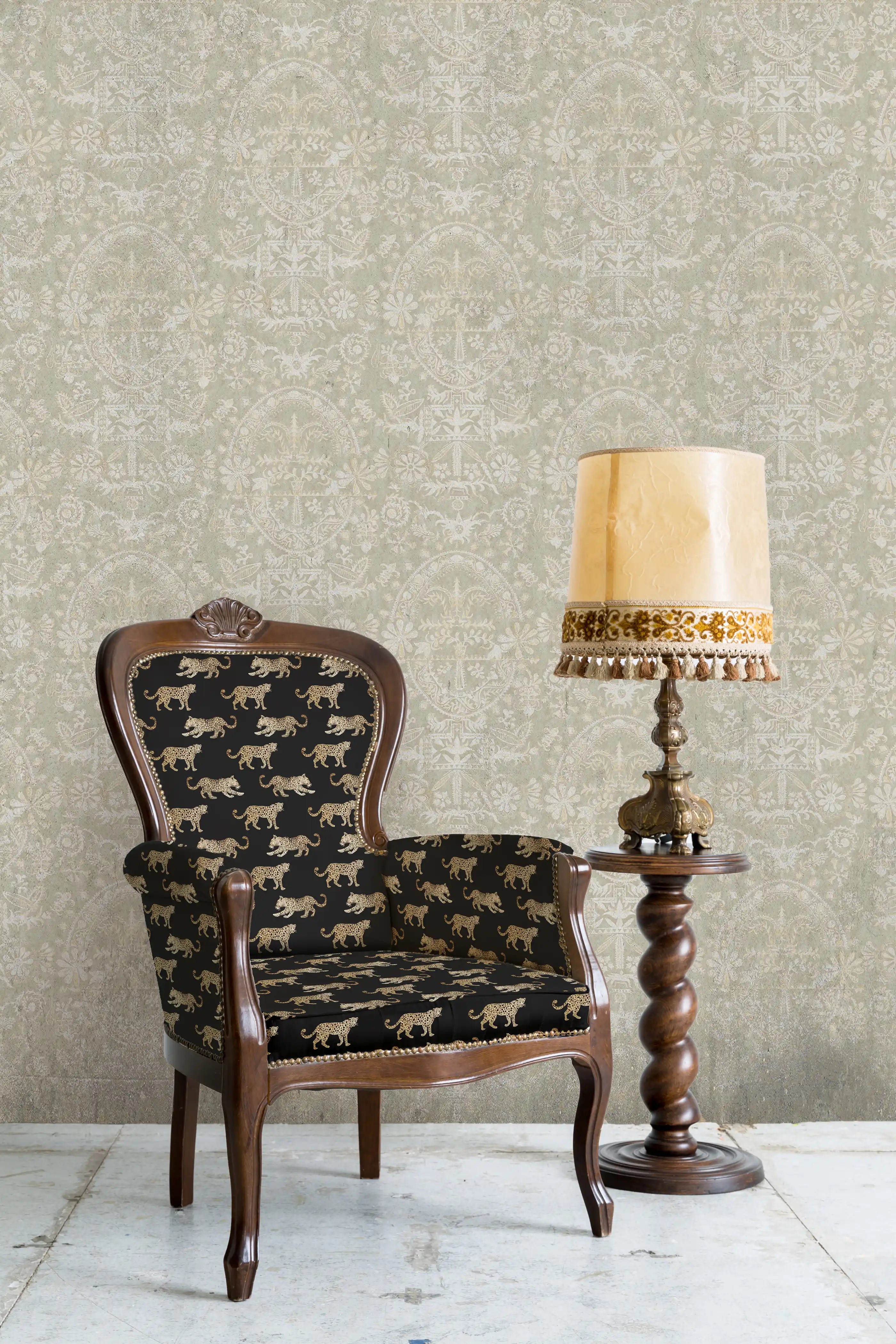Decorative armchair with patterned backrest and seat next to a lamp against a textured wall.