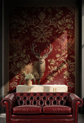 Red leather sofa in front of a decorative wall with a deer and floral pattern.