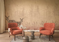 Two orange armchairs in a room with a decorative wall featuring deer and nature.