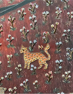 Decorative brooch with a cat design on a floral patterned background