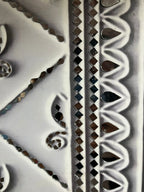 Decorative tile with intricate patterns and textures on a white background