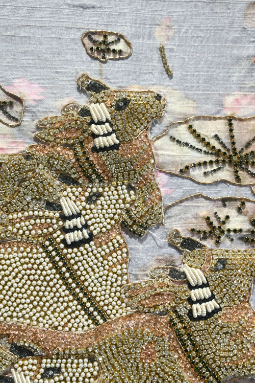 Close-up of a beaded animal figure with intricate patterns on a textured background