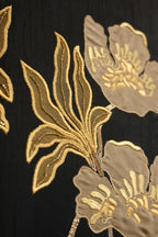 Close-up of gold floral embroidery on black fabric