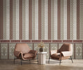 Two brown armchairs with a small round table against a decorative wall with vertical stripes and geometric patterns.