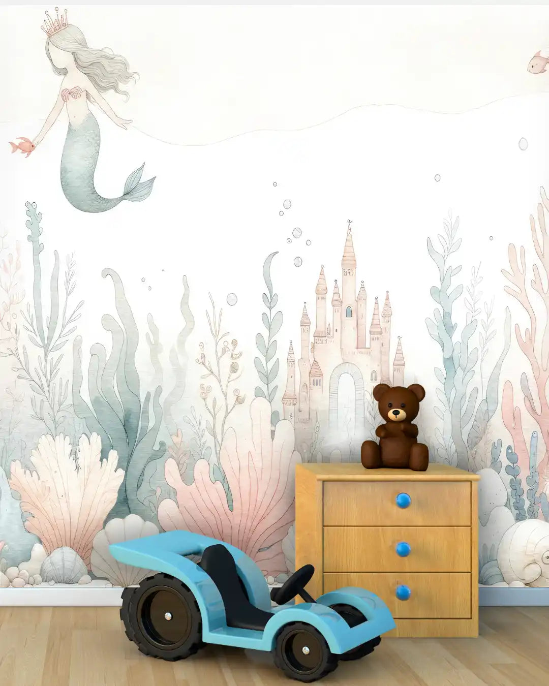 Children's room with mermaid wall mural, toy car, teddy bear, and wooden dresser.