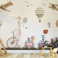 Children's room with a decorative wall mural featuring a giraffe, hot air balloon, and airplane.