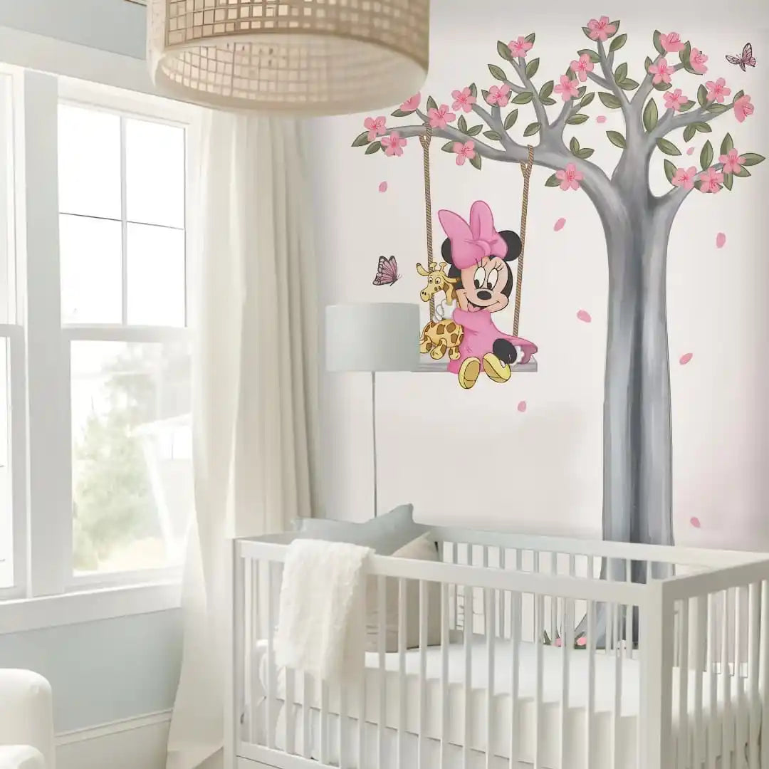 Children's room with a crib and Minnie Mouse wall decal on a tree.