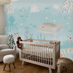 Nursery room with crib and ocean-themed wallpaper