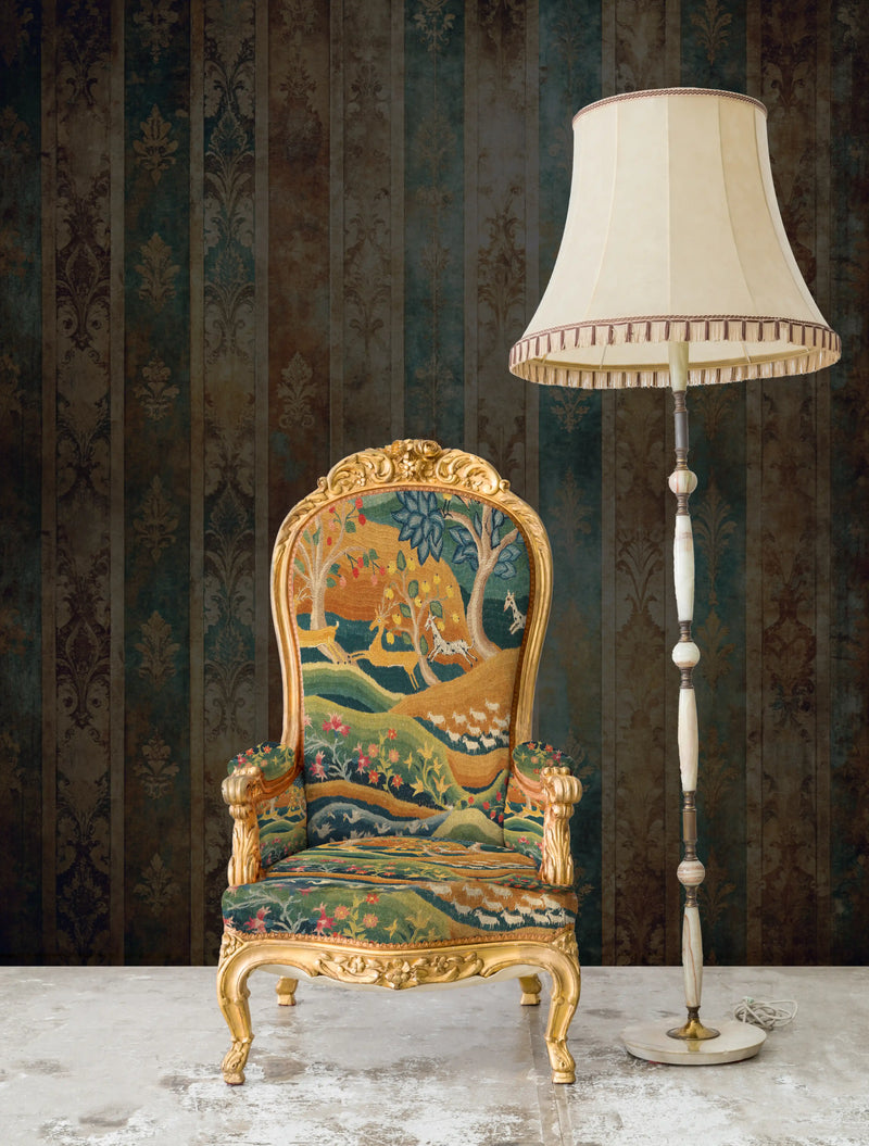 Decorative armchair with intricate patterns and gold accents next to a tall floor lamp against a patterned wall.