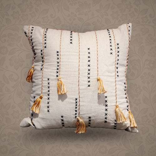 Decorative pillow with tassels on a patterned background